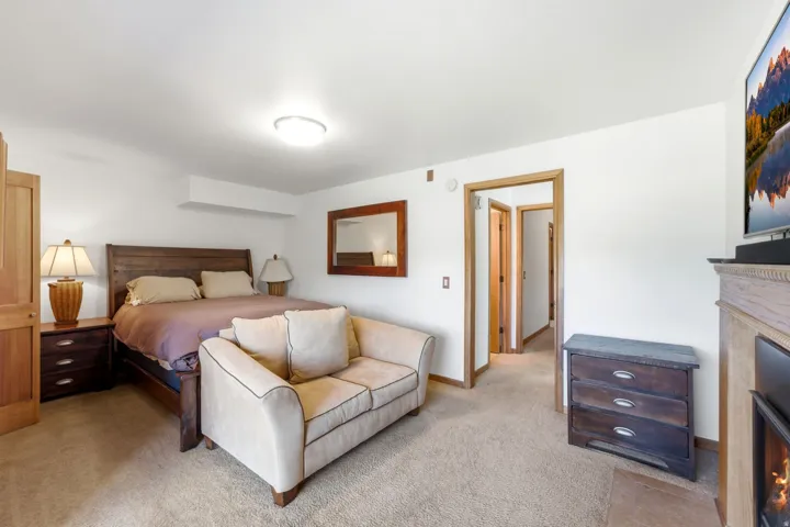 Recessed lighting, wood-finish door frames, and a built-in fireplace with a carved mantel