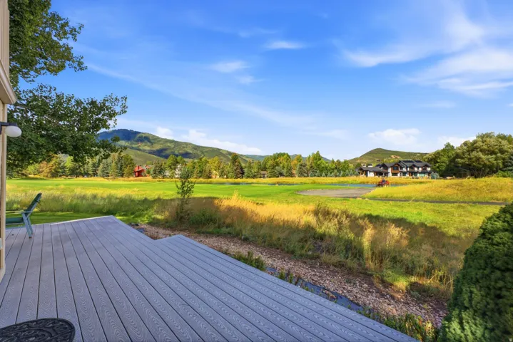 Expansive outdoor deck with mountain and green space scenery