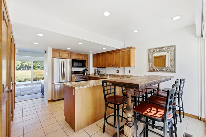 Kitchen featuring wood cabinetry, stainless steel appliances, and granite countertops