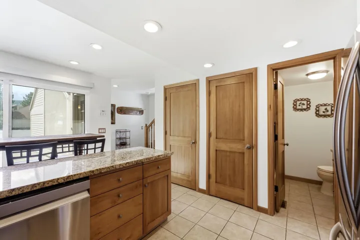 Kitchen island with granite countertop and wood cabinetry