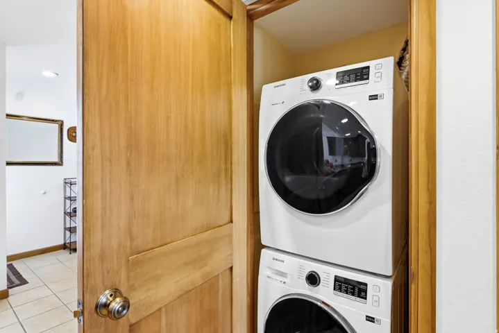 Integrated laundry area featuring a stacked washer and dryer