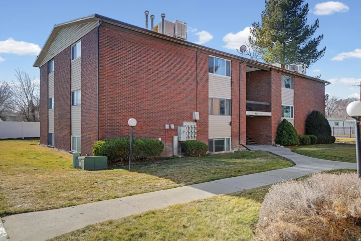 Brick exterior with horizontal siding accents, multiple windows, and a paved walkway