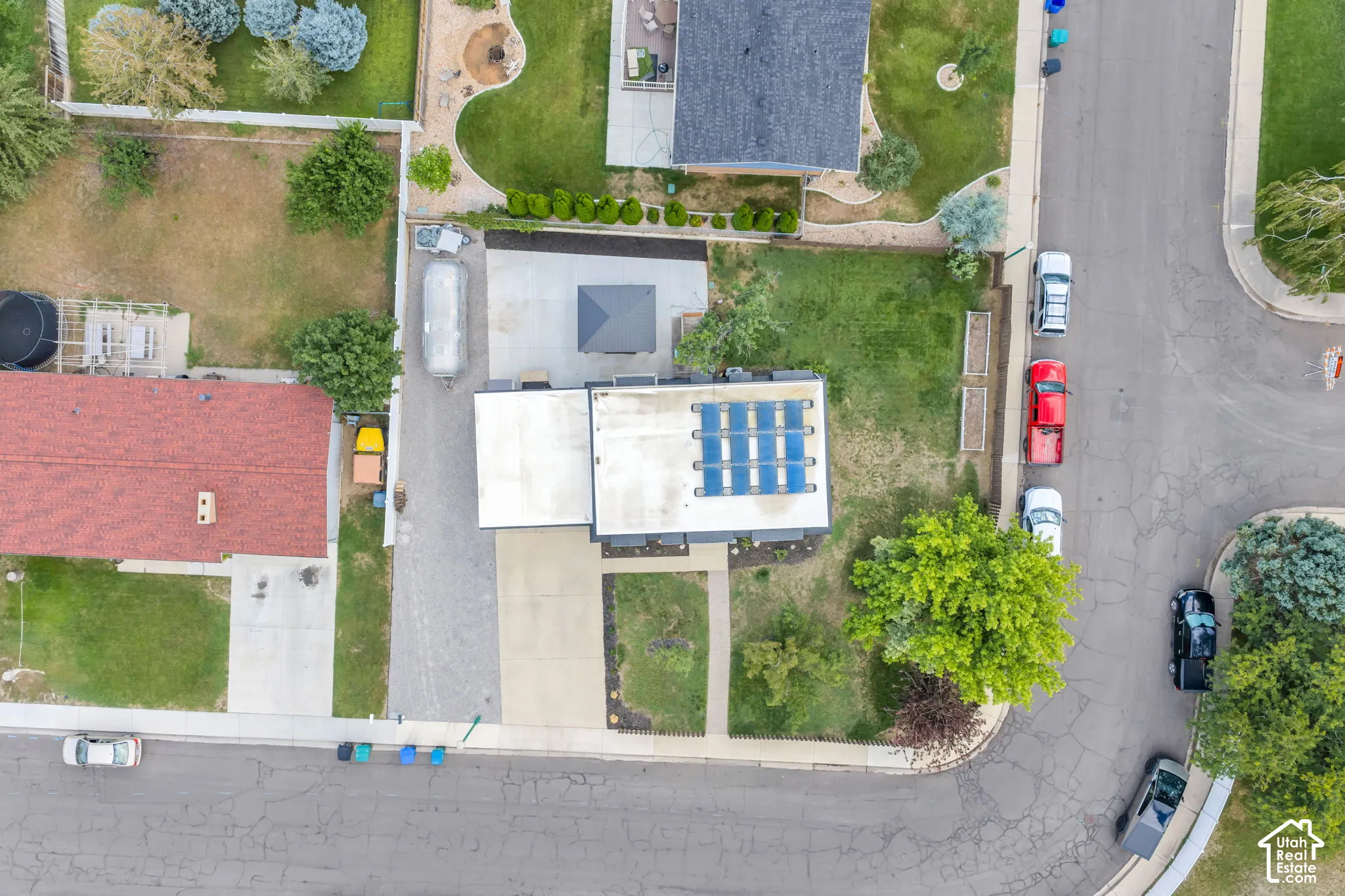 Rooftop solar panels, a paved driveway, and a concrete walkway