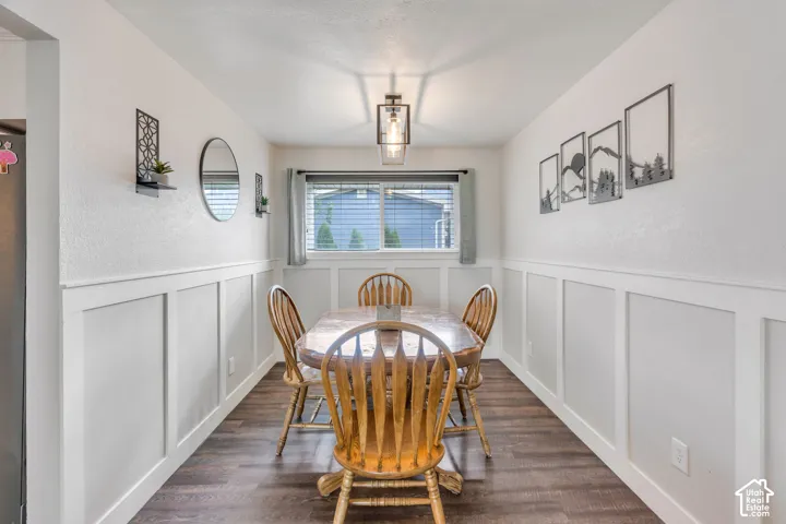 Wood-finish flooring, half-wall wainscoting, and a central window with blinds