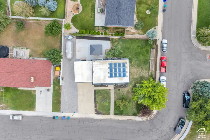 Rooftop solar panels, a paved driveway, and a concrete walkway