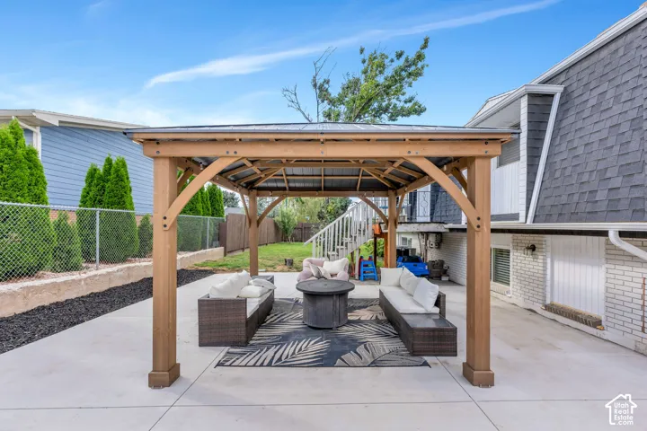 Large concrete patio with a wooden gazebo and metal roof