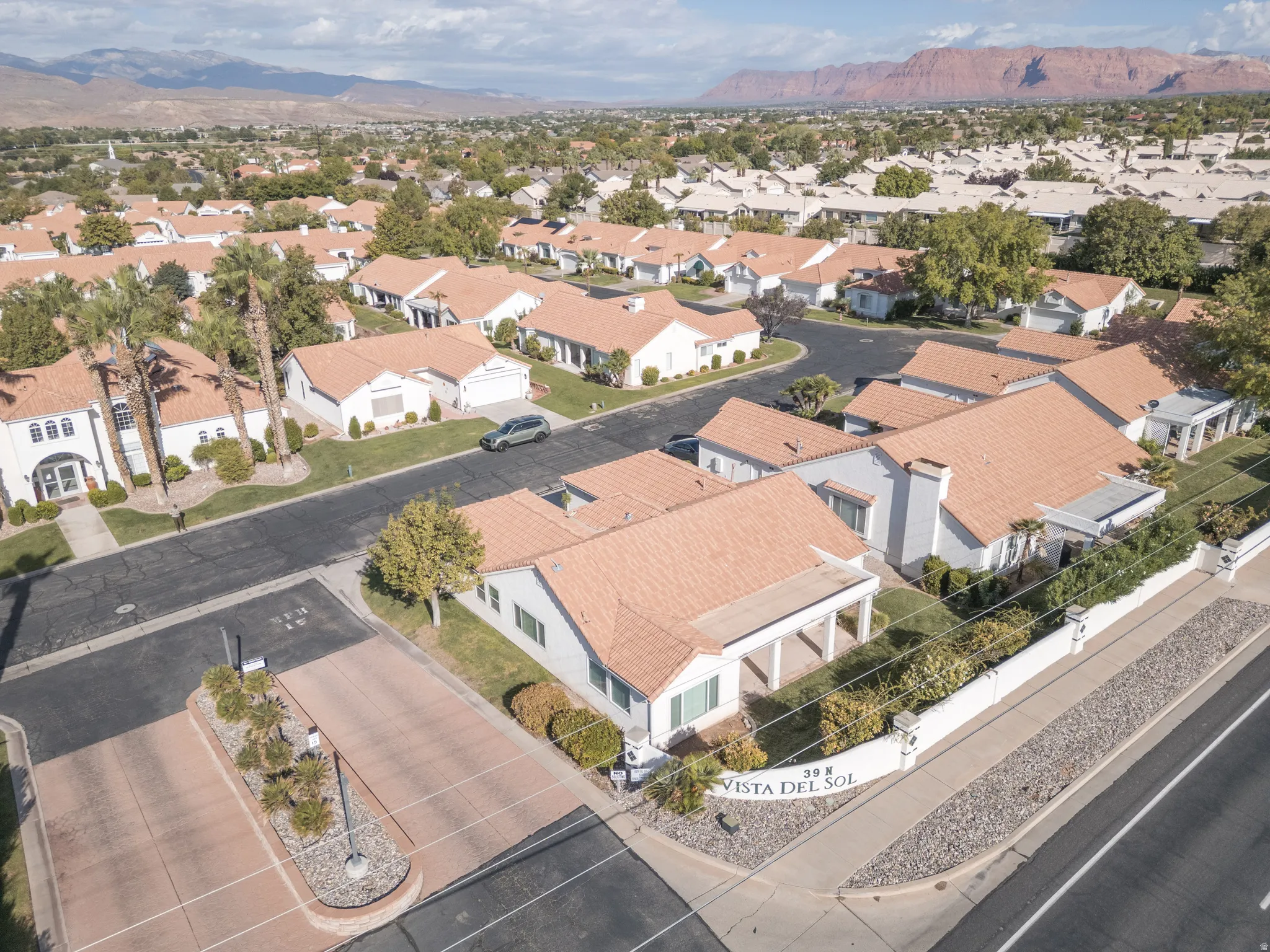 Aerial perspective showcasing a residential community with abundant mature trees and mountainous backdrops