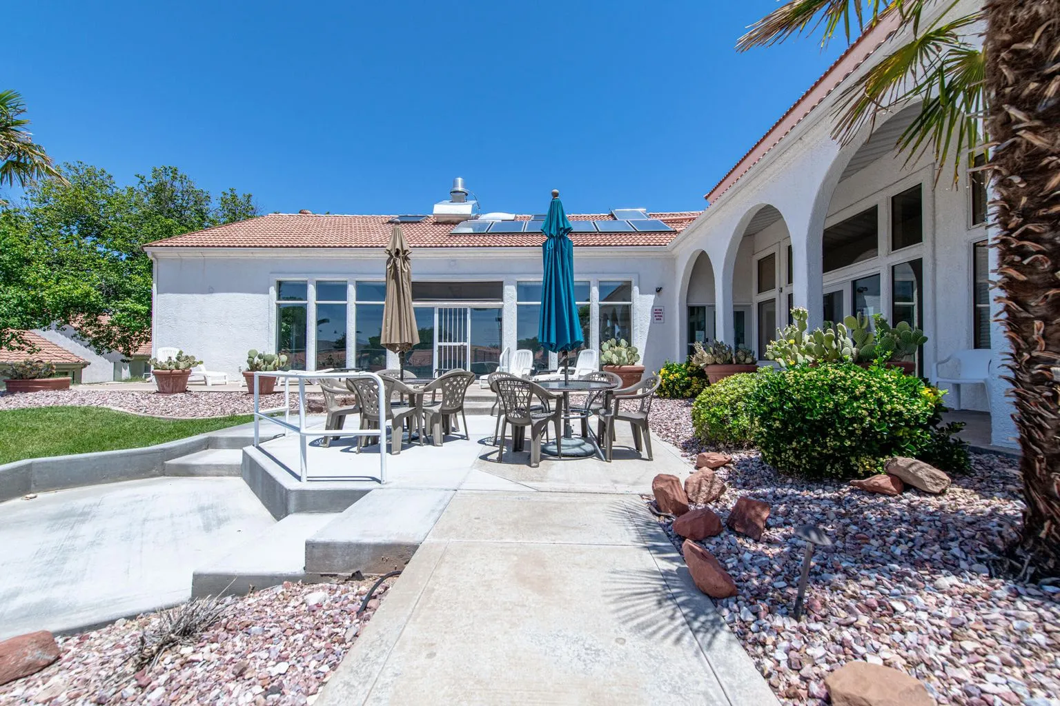 Expansive patio area with concrete steps, xeriscape landscaping, and a tile roof