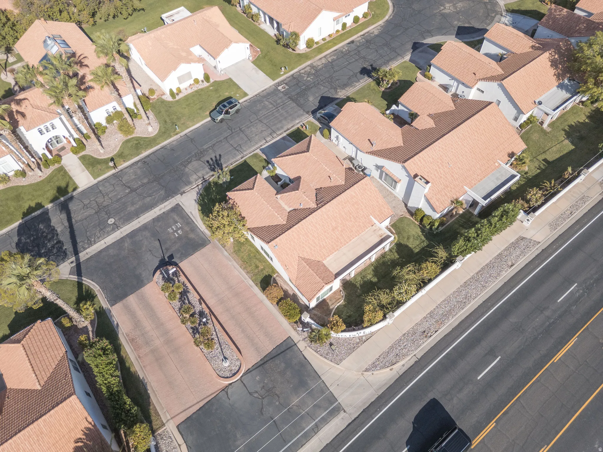 Aerial perspective of a residential neighborhood featuring terracotta-tiled roofs, mature landscaping, and an organized street grid