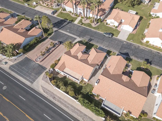 Paved driveways, tile roofs, and mature landscaping define the property