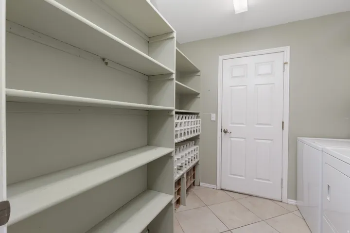 Expansive built-in shelving, durable tile flooring, and integrated storage cubbies