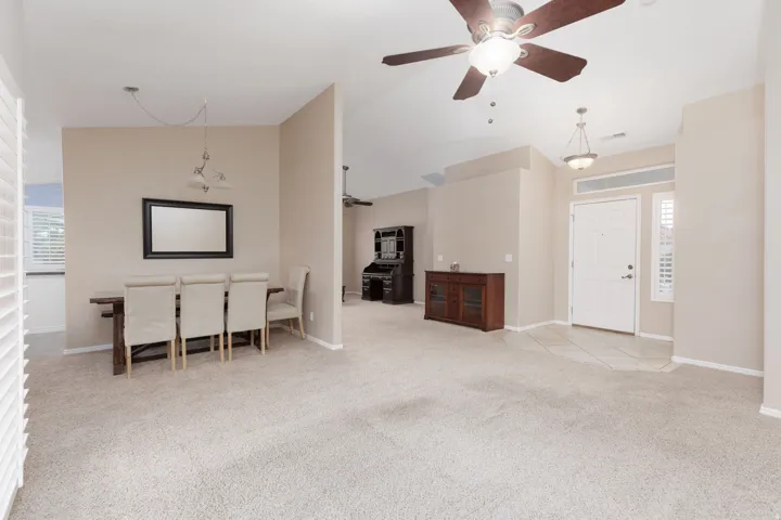 Vaulted ceilings with ceiling fans, neutral wall tones, and carpet flooring throughout