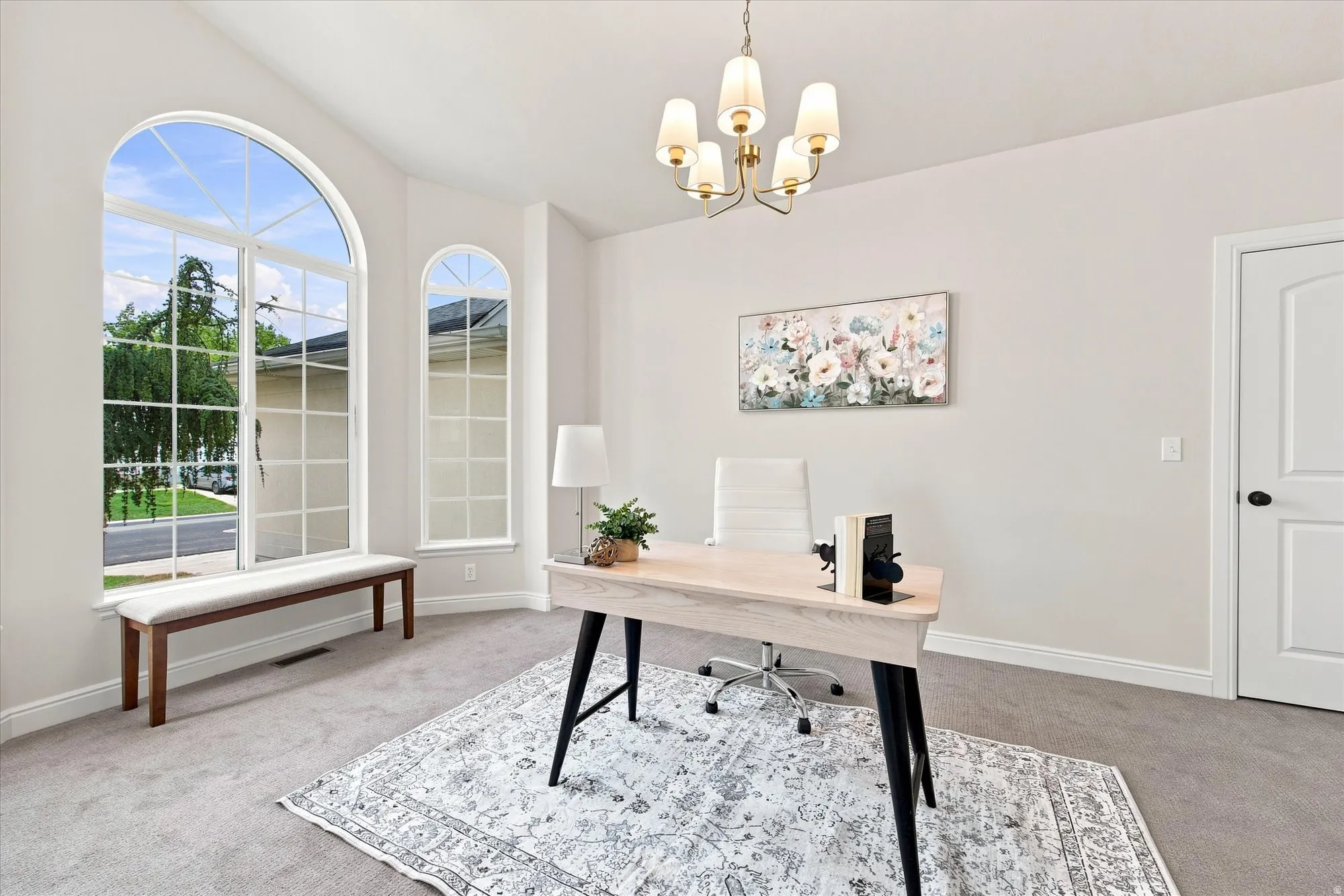 Arched windows, recessed lighting, and a modern chandelier