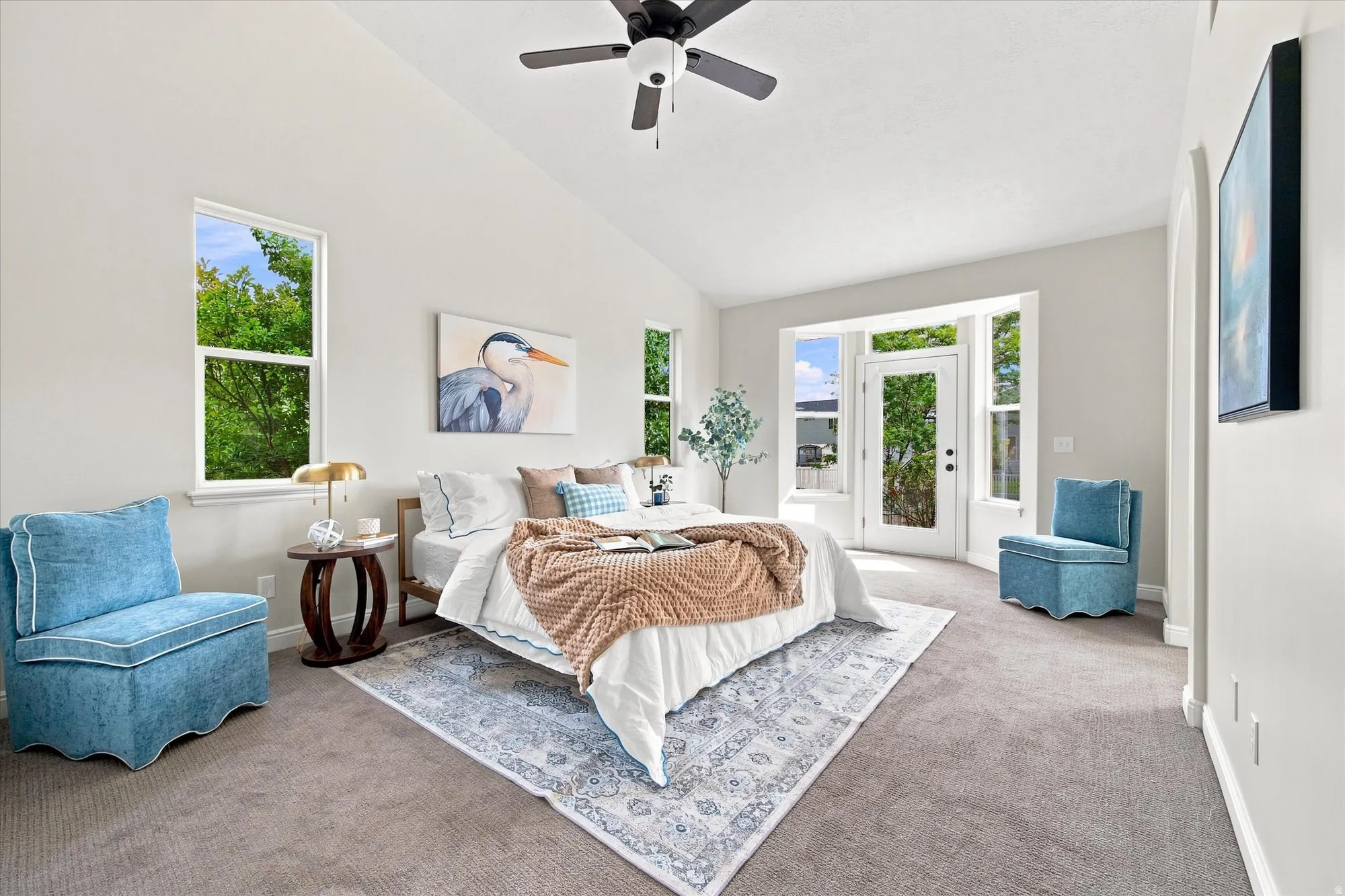 Vaulted ceiling with a ceiling fan, multiple windows, and a glass-paneled door