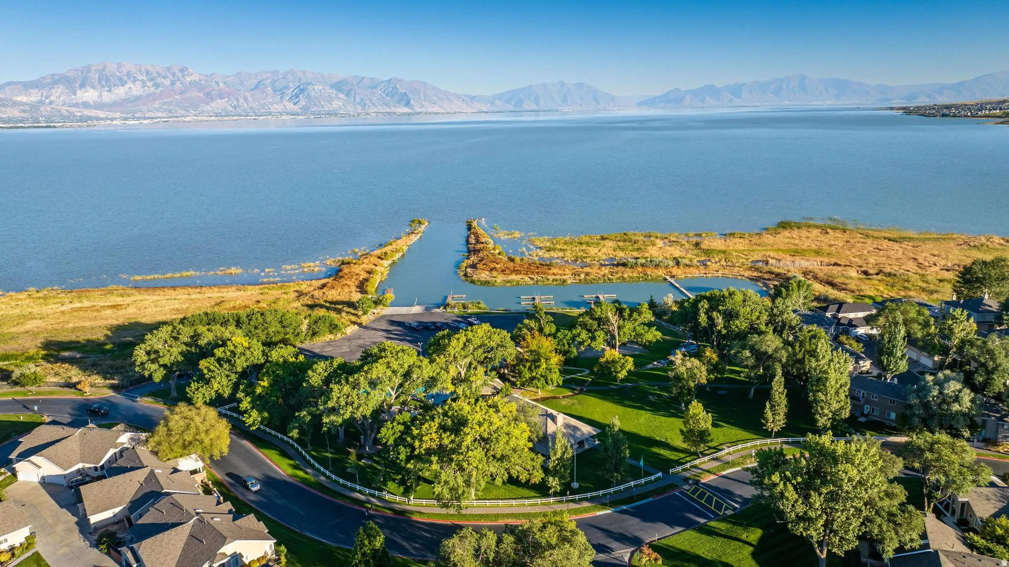 Expansive body of water with distant mountains, lush green spaces, and distinct waterways