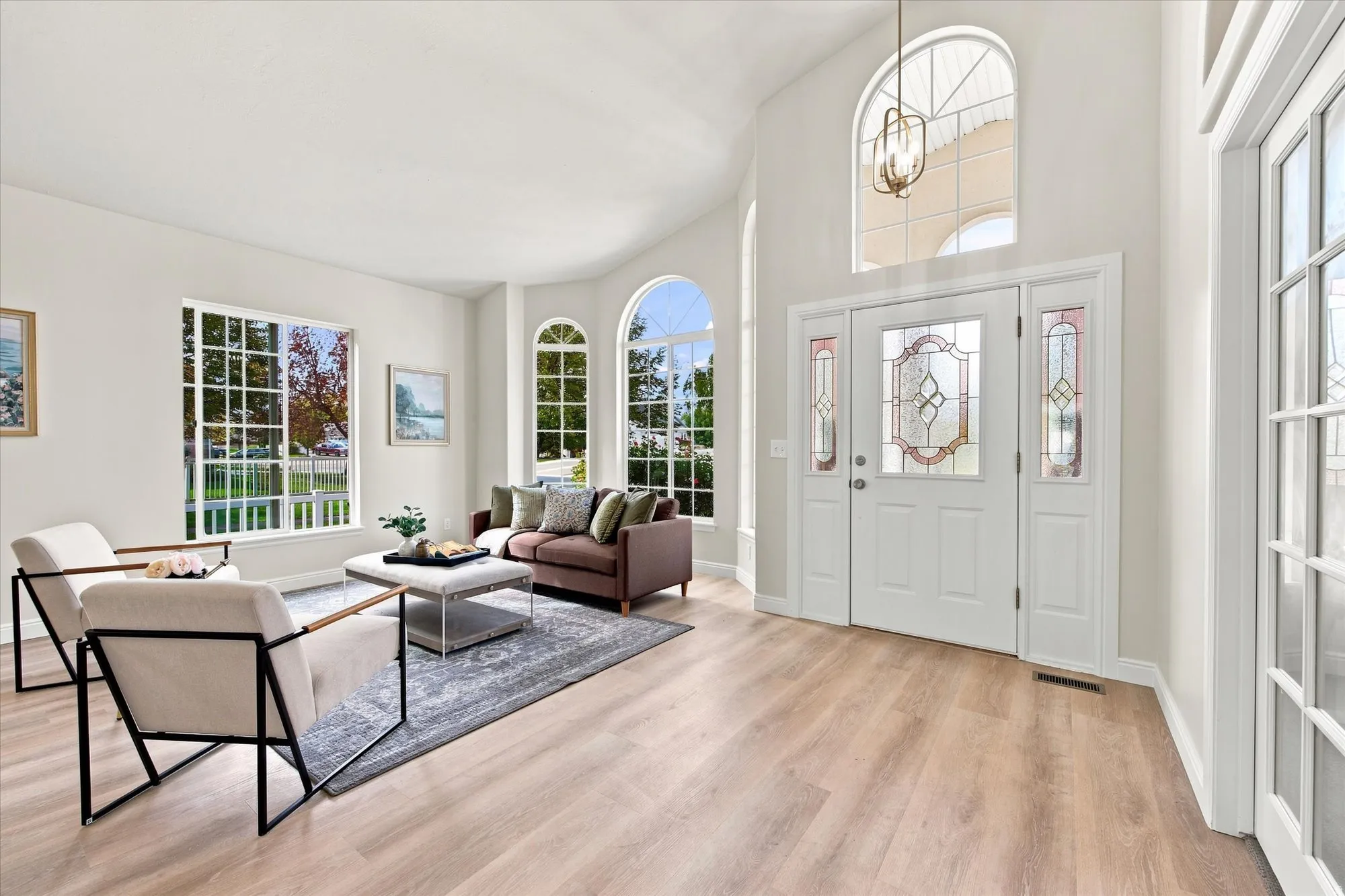 Double entry doors with decorative glass panels, arched transom window, and sidelights