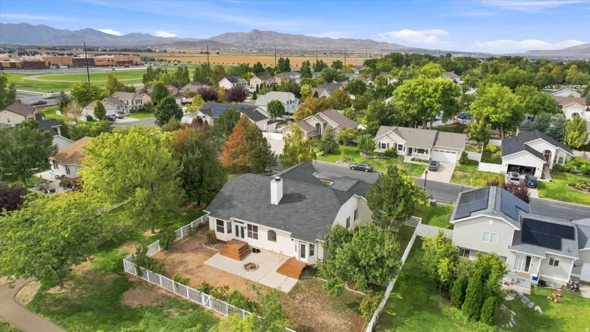 Expansive backyard featuring a white picket fence, concrete patio, and a wood deck