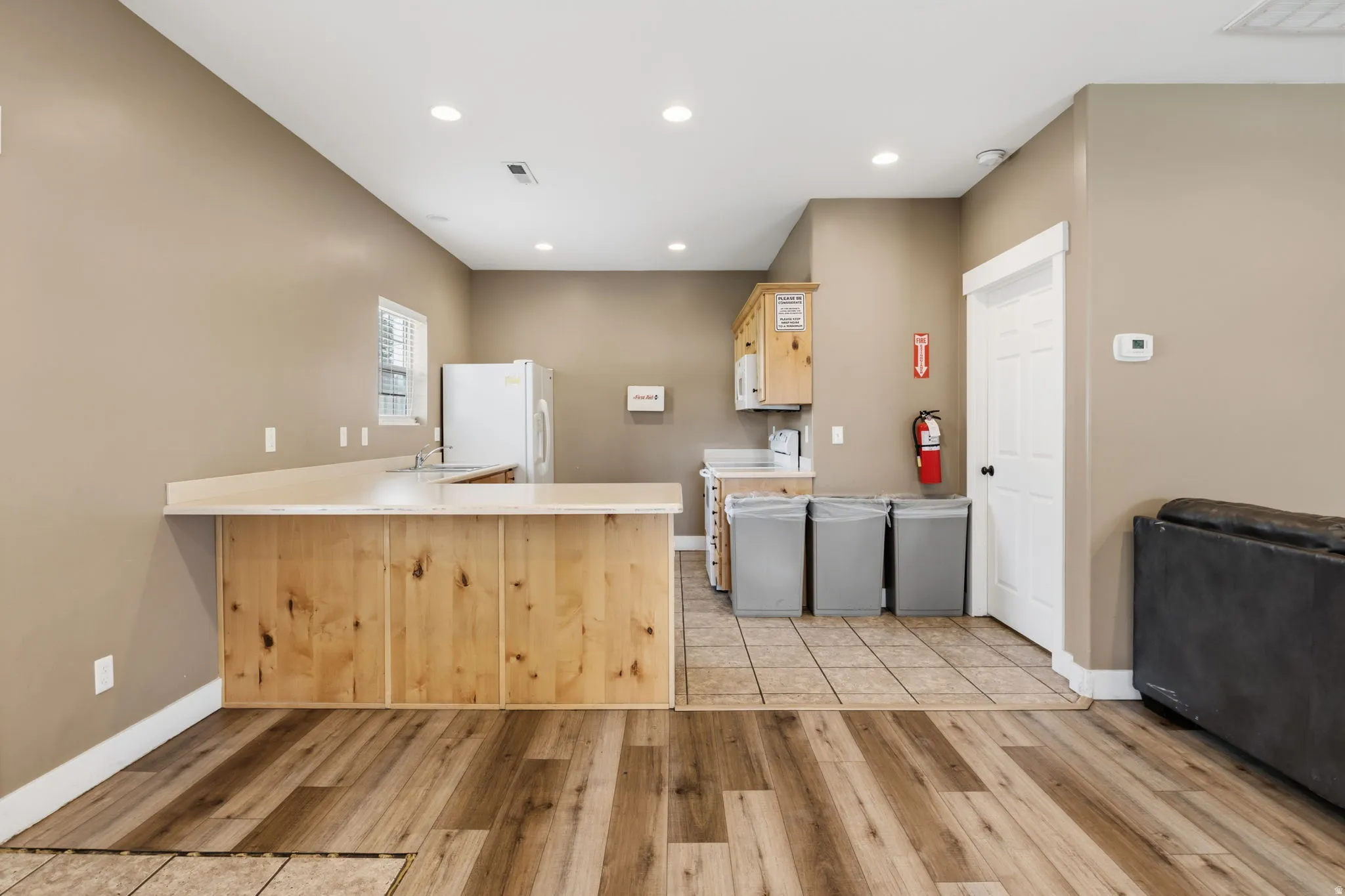 Wood-finish flooring, recessed lighting, neutral wall paint, and built-in wood cabinetry