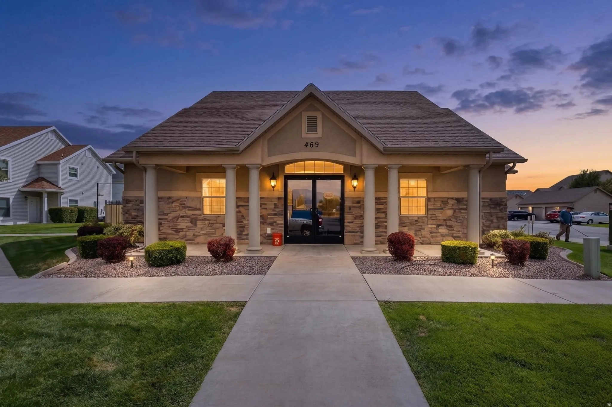 Building exterior featuring a gabled roof, stone veneer accents, and four decorative columns