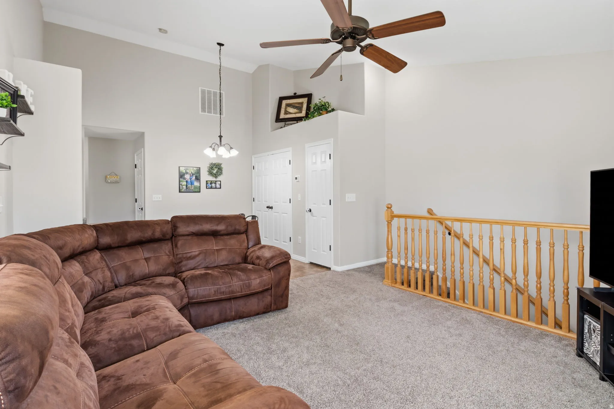 Vaulted ceilings with crown molding, ceiling fan, and carpeted flooring