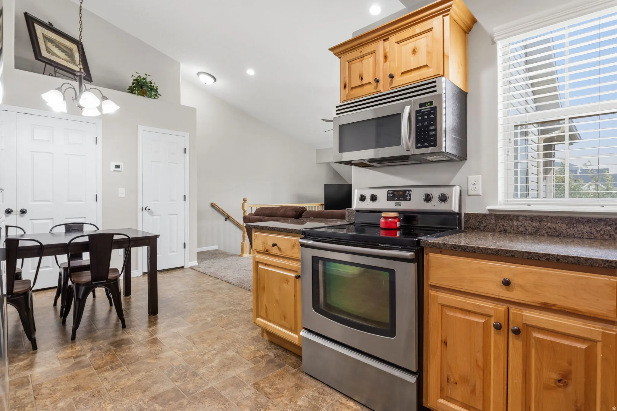 Kitchen featuring wood cabinetry, stainless steel appliances, and stone-look countertops