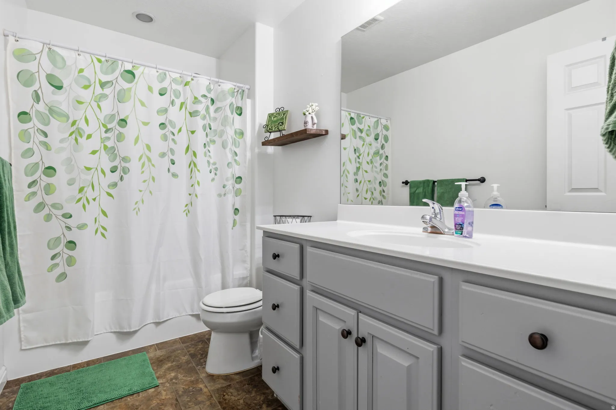 Recessed lighting, single vanity with light grey cabinetry, white countertop, and a large wall-mounted mirror