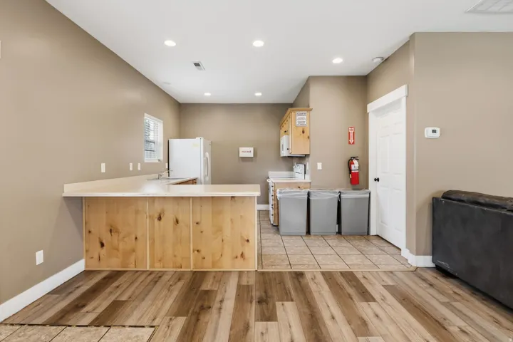 Wood-finish flooring, recessed lighting, neutral wall paint, and built-in wood cabinetry