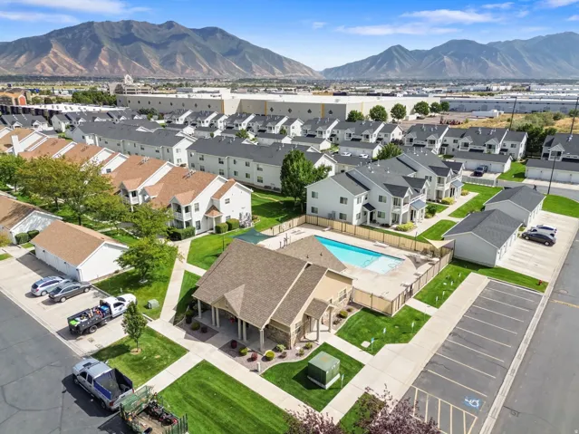 Mountain backdrop, residential development, community pool, paved parking, and manicured green spaces
