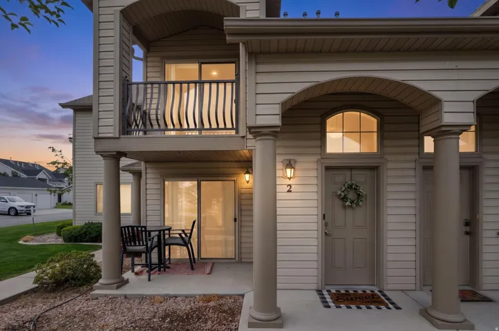 Siding exterior with archways, a balcony, and an outdoor patio space