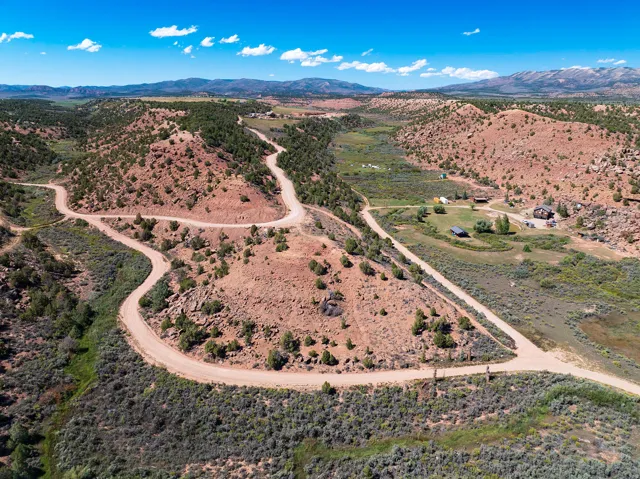 Winding dirt roads traversing rugged terrain with sparse vegetation