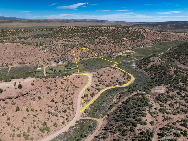 Expansive rural landscape featuring a winding dirt road and scattered vegetation