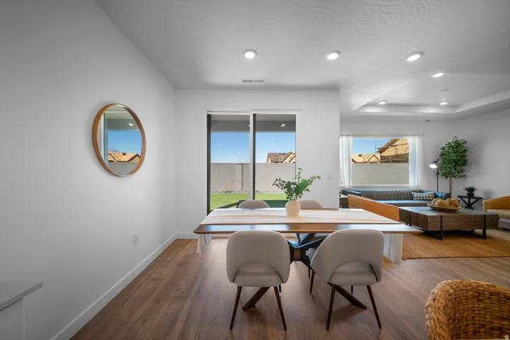 Open-concept living space with wood-finish flooring, recessed lighting, and a sliding glass door to the exterior