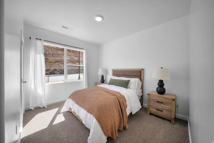 Recessed ceiling lighting, large window, neutral carpeting, and a light-toned door