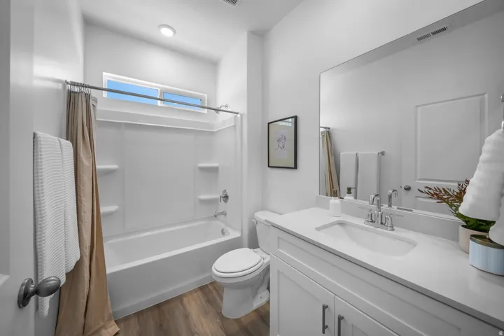 Bathroom featuring a white vanity with an integrated sink, polished chrome faucet, and a large wall-mounted mirror