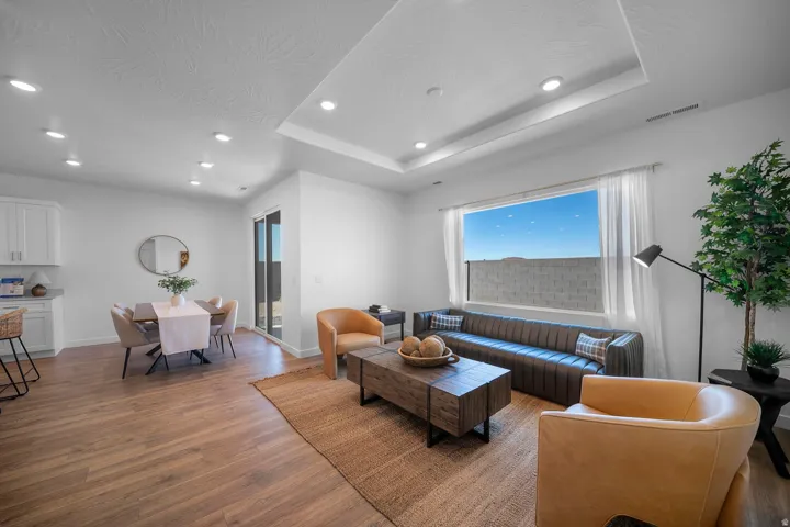 Recessed lighting, tray ceiling, sliding glass door, wood-finish flooring, white cabinetry