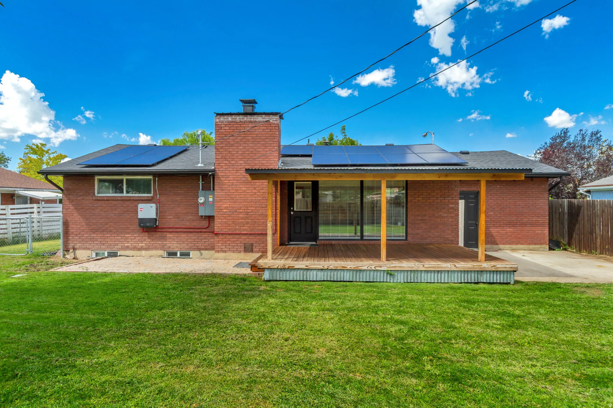 Back of Home with large Covered Deck and Patio looking eastward toward stunning mountain views