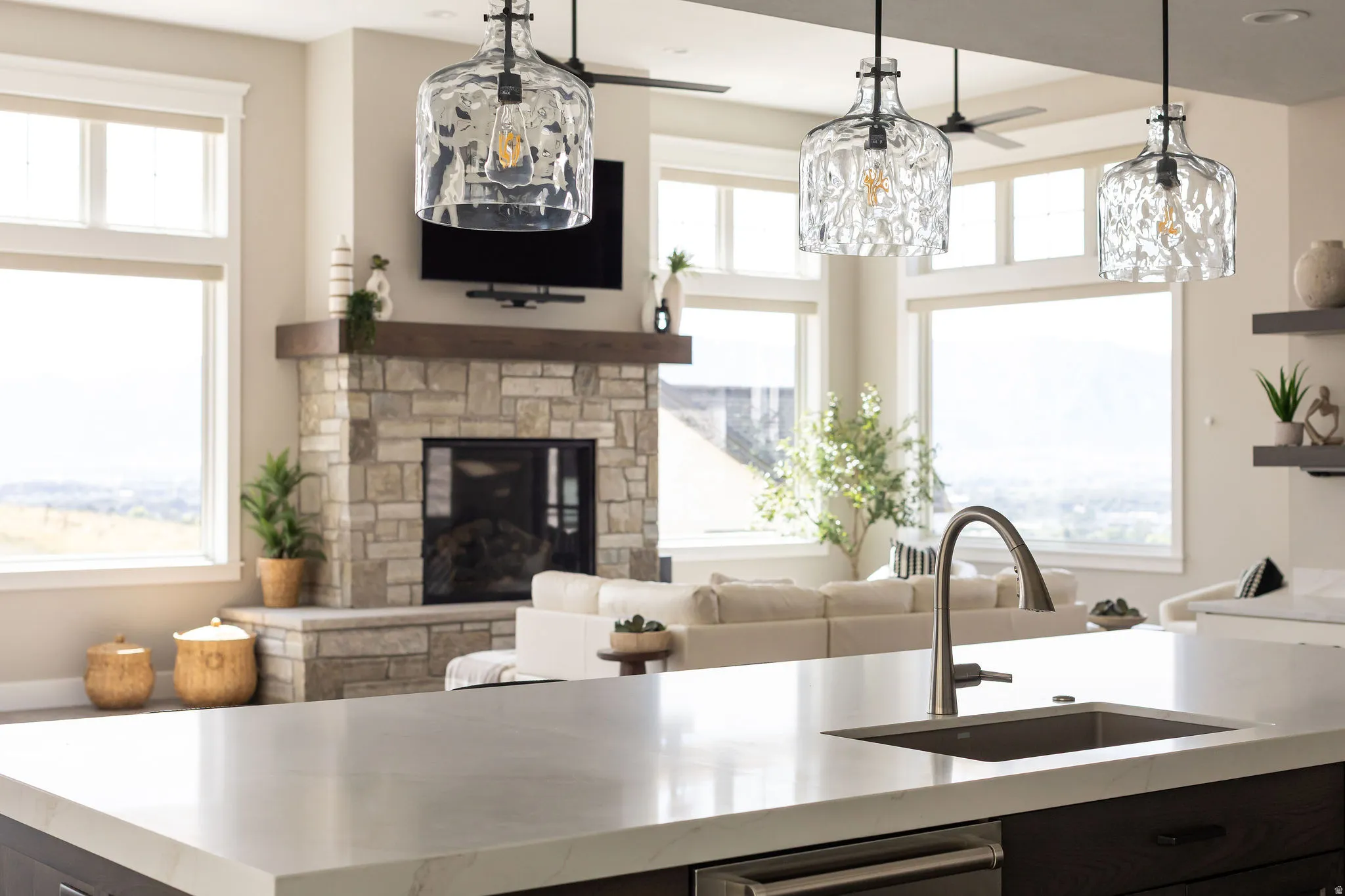 Kitchen island with an undermount sink, gooseneck faucet, and light-toned countertop