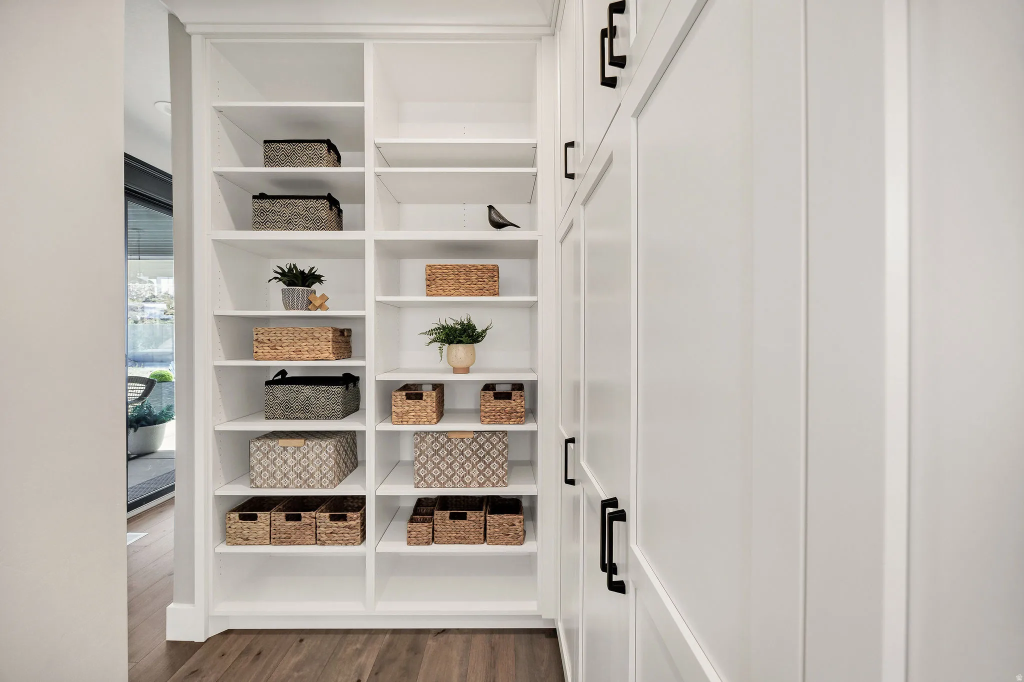White built-in shelving and cabinetry with matte black hardware