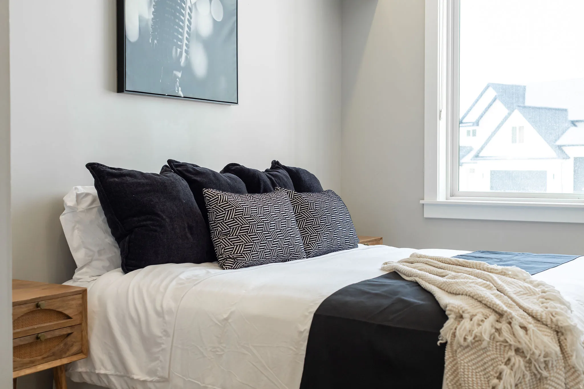 White window trim, light gray painted wall, and a wooden nightstand with two drawers