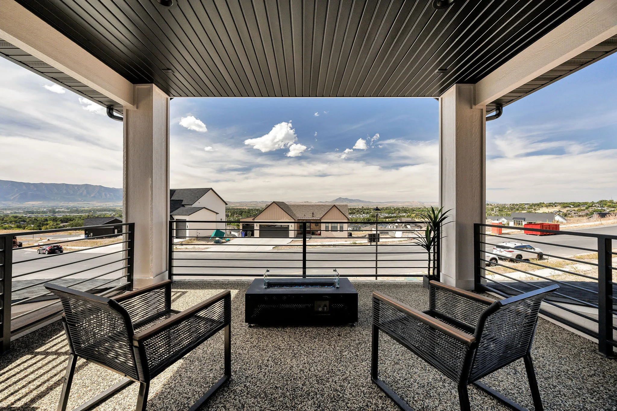 Covered balcony with a dark plank ceiling and exposed aggregate flooring