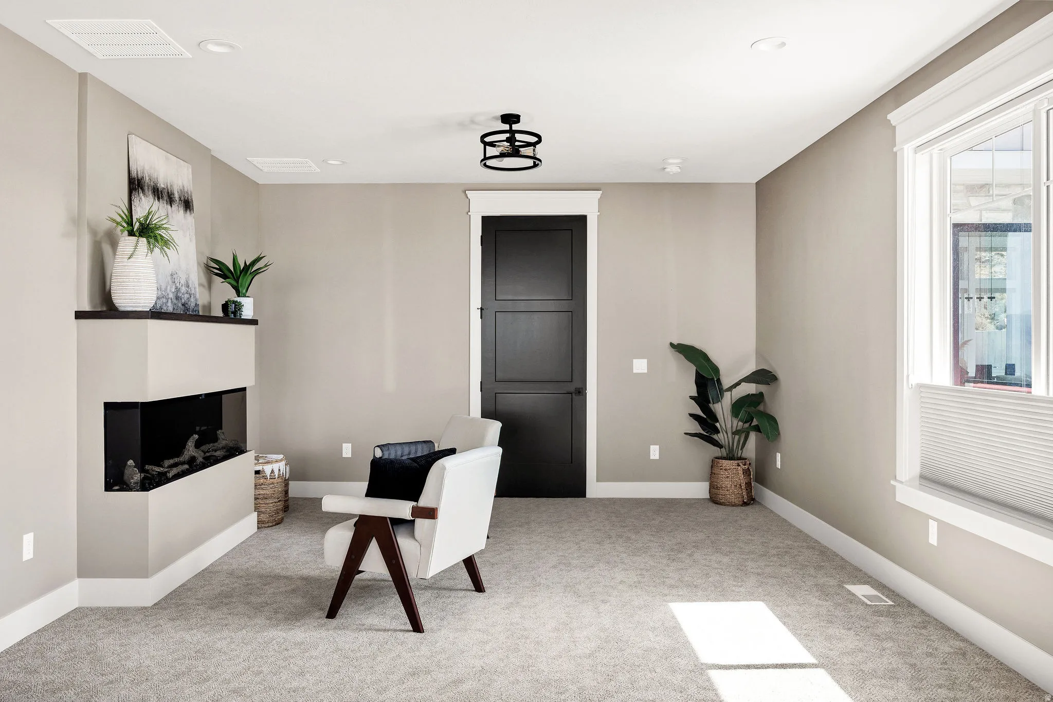 Corner fireplace with a dark mantel, recessed lighting, ceiling light fixture, white trim, and light-colored carpet