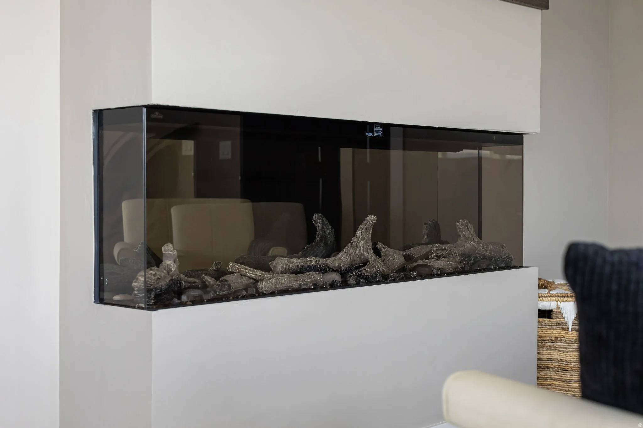 Built-in corner fireplace with glass enclosure and decorative logs