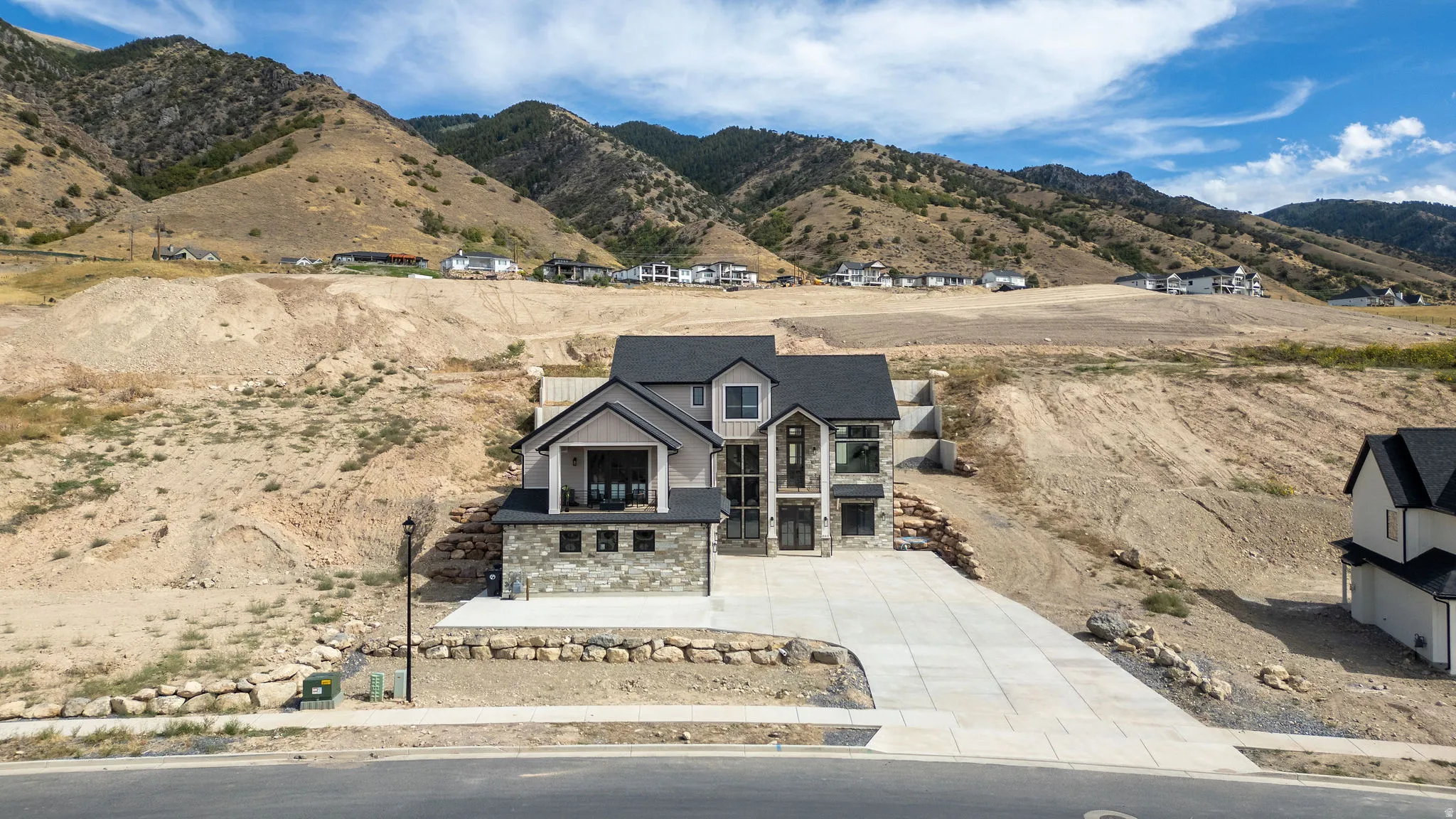 Modern exterior featuring mixed materials, large format windows, a 3-car garage, and a concrete driveway