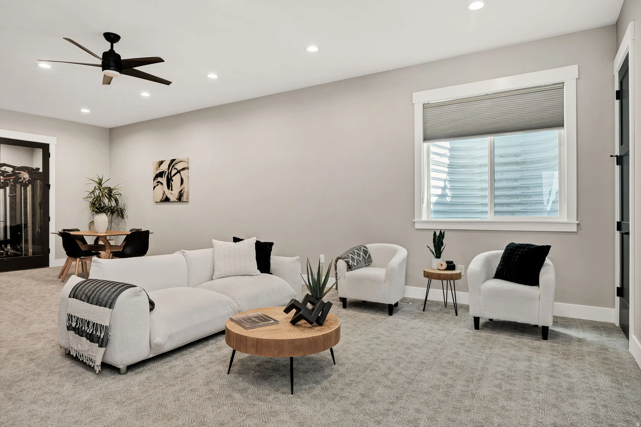 Recessed lighting, ceiling fan, and carpeted flooring in a versatile living space