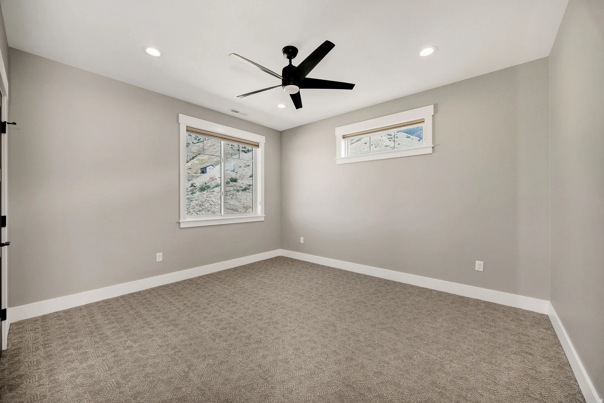 Recessed lighting, ceiling fan, neutral wall paint, white trim, carpet flooring