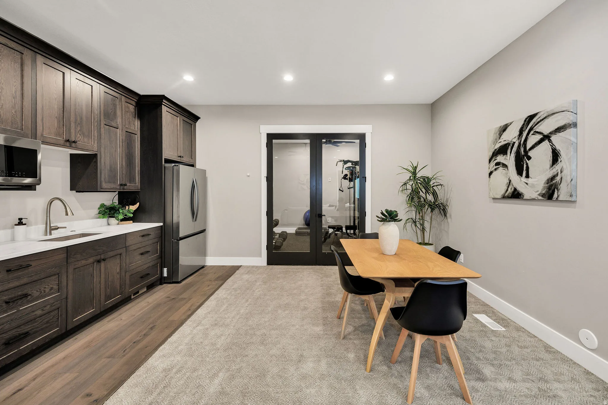 Kitchenette featuring dark wood cabinetry, stainless steel appliances, and a white countertop
