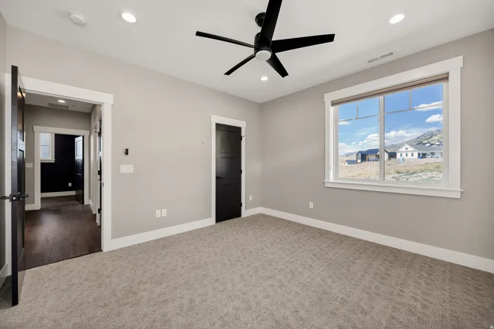 Recessed lighting, ceiling fan, carpeting, dark interior doors, and white trim
