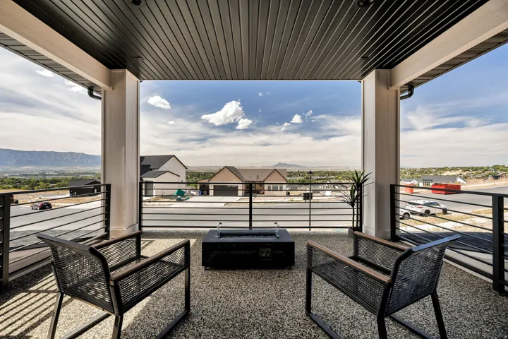 Covered balcony with a dark plank ceiling and exposed aggregate flooring