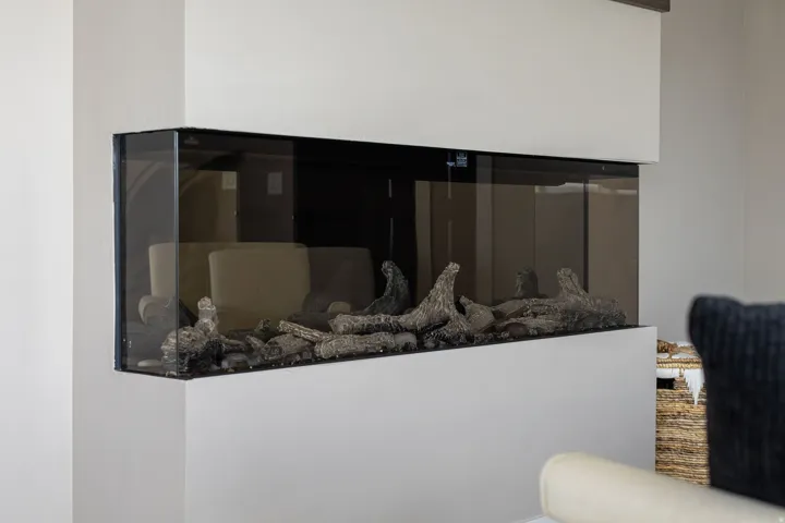Built-in corner fireplace with glass enclosure and decorative logs