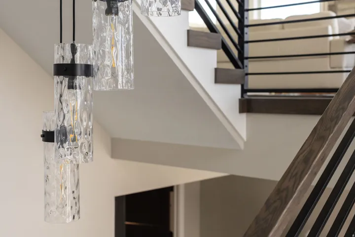 Floating staircase featuring wood-finish treads and risers, with a black metal railing